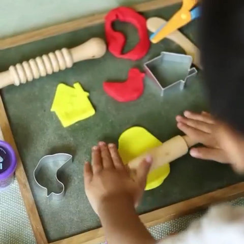 Child using rolling pin to roll the clay and dough and play with cutter .Comprehensive Creative Play Dough Kit with tools, perfect for kids to experiment, create, and explore textures.