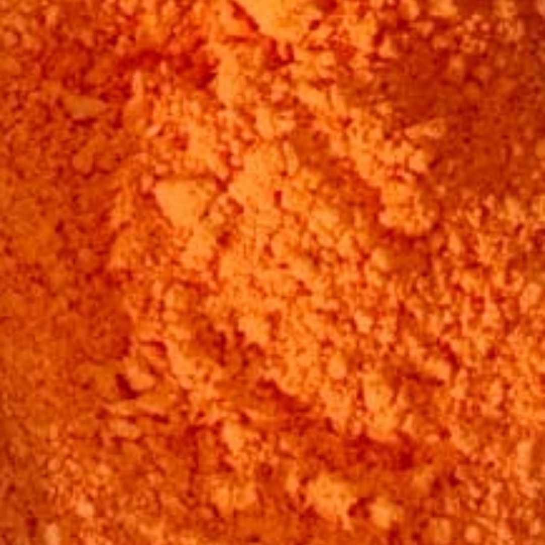 Bright orange Holi color (gulal) powder, finely ground and spread out, representing energy, warmth, and festive spirit.