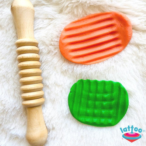 Rolling pin with rings pattern, orange and green colored dough with some patterned impressions.Patterned Rolling Pin for kids, featuring engraved designs perfect for creating textured patterns in play dough or baking projects. Ideal for encouraging creativity and fine motor skills during hands-on play.